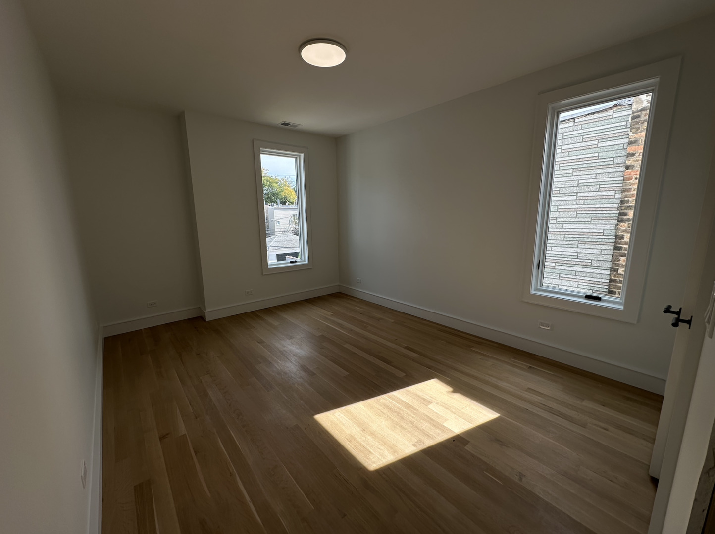 4243 North Damen Avenue, Unit 1F Chicago, IL 60618 - Photo 30 of 42 an empty room with wooden floor and windows