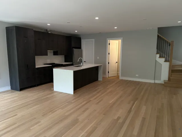 a kitchen with stainless steel appliances granite countertop a refrigerator and a stove top oven