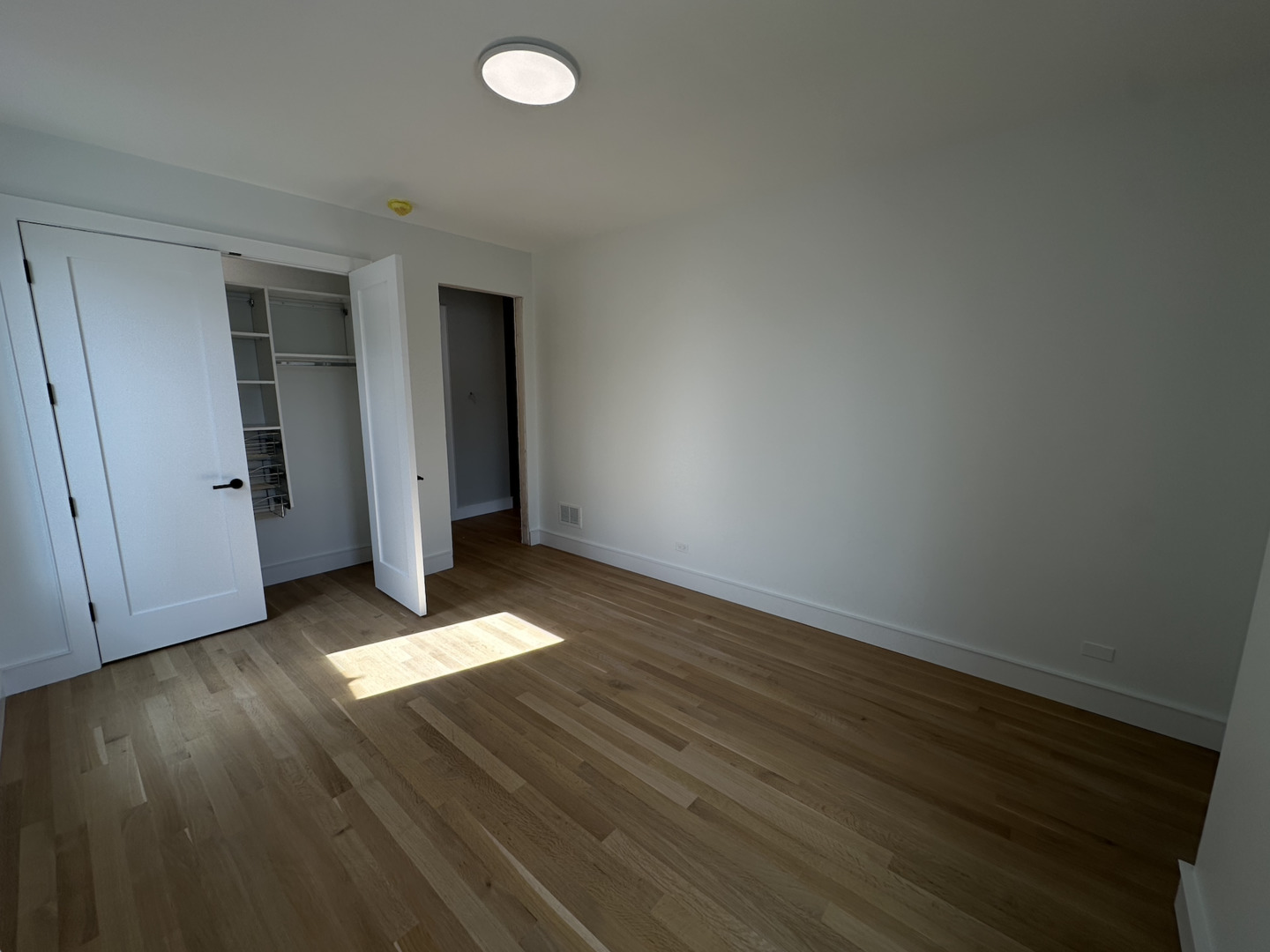 4243 North Damen Avenue, Unit 1F Chicago, IL 60618 - Photo 32 of 42 an empty room with wooden floor and windows
