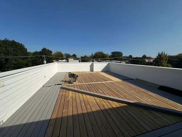 a view of a balcony with wooden floor and outdoor space