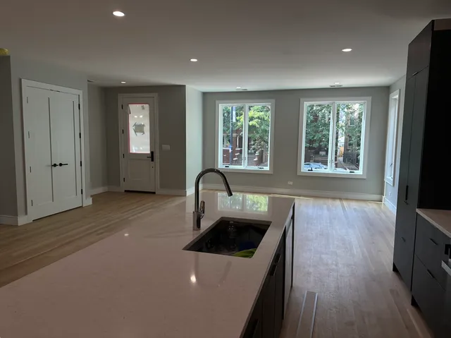 a kitchen with a sink a stove and wooden floor