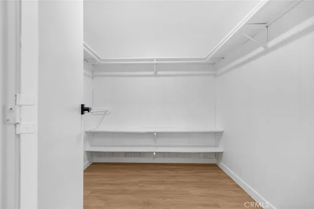 a kitchen with white cabinets and wooden floor