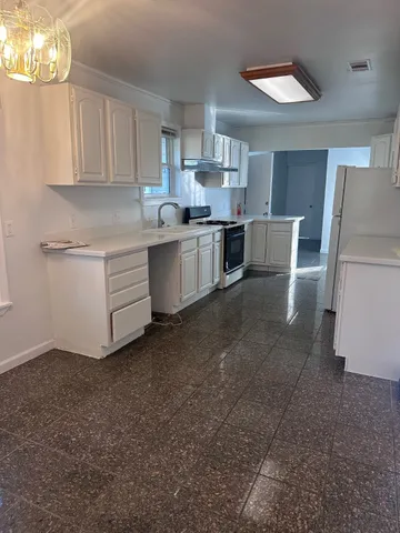 a kitchen with cabinets and a refrigerator