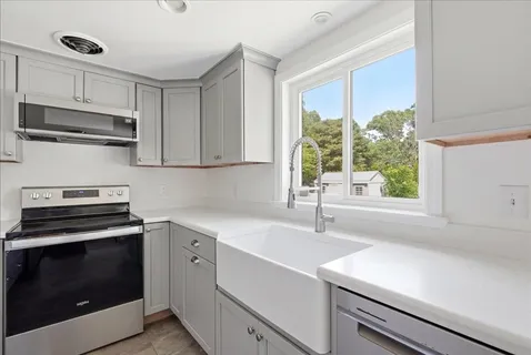 a kitchen with a sink stove and microwave