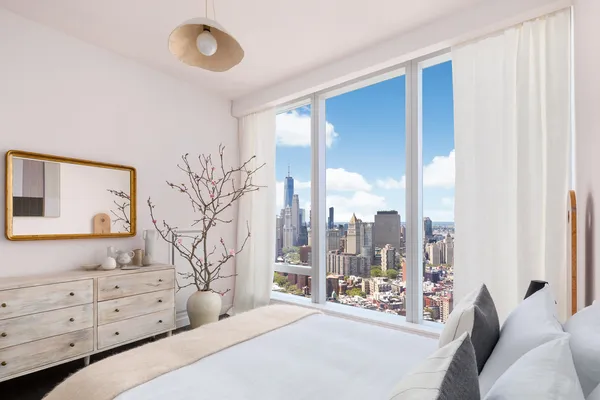 a bedroom with a large bed and a large window with outer view