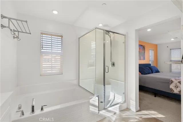 a spacious bathroom with a tub shower and windows