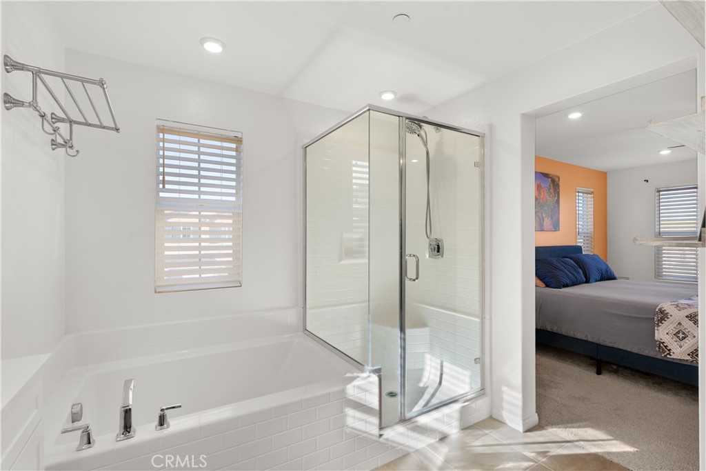 904 Maya Crossing, Unit 19 Lake Elsinore, CA 92530 - Photo 16 of 25 a spacious bathroom with a tub shower and windows