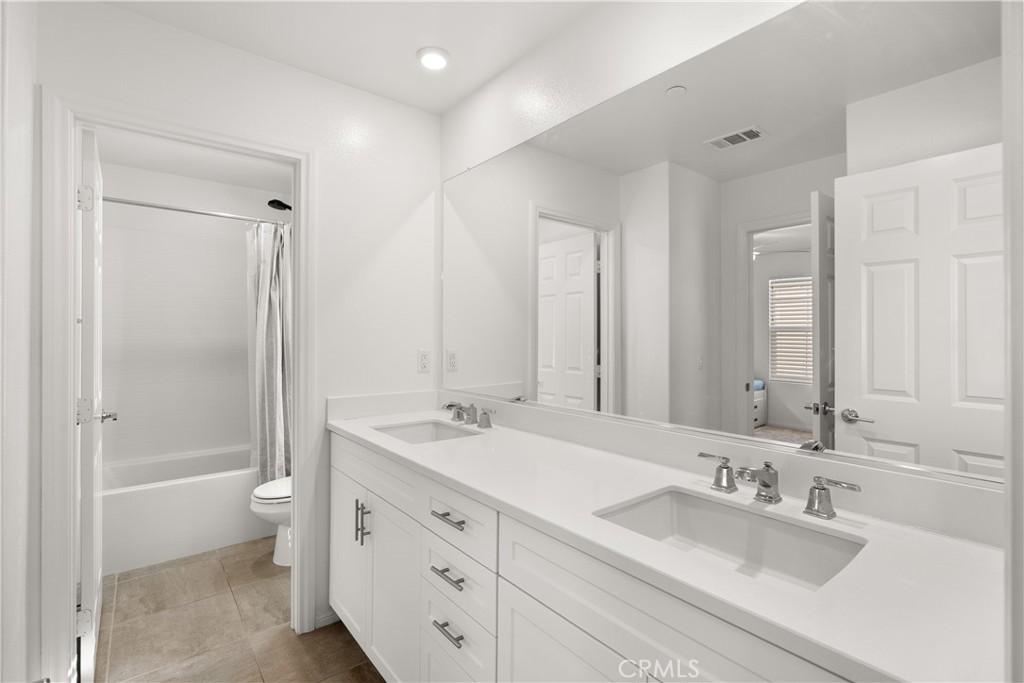 904 Maya Crossing, Unit 19 Lake Elsinore, CA 92530 - Photo 19 of 25 a bathroom with a double vanity sink toilet mirror and bathtub