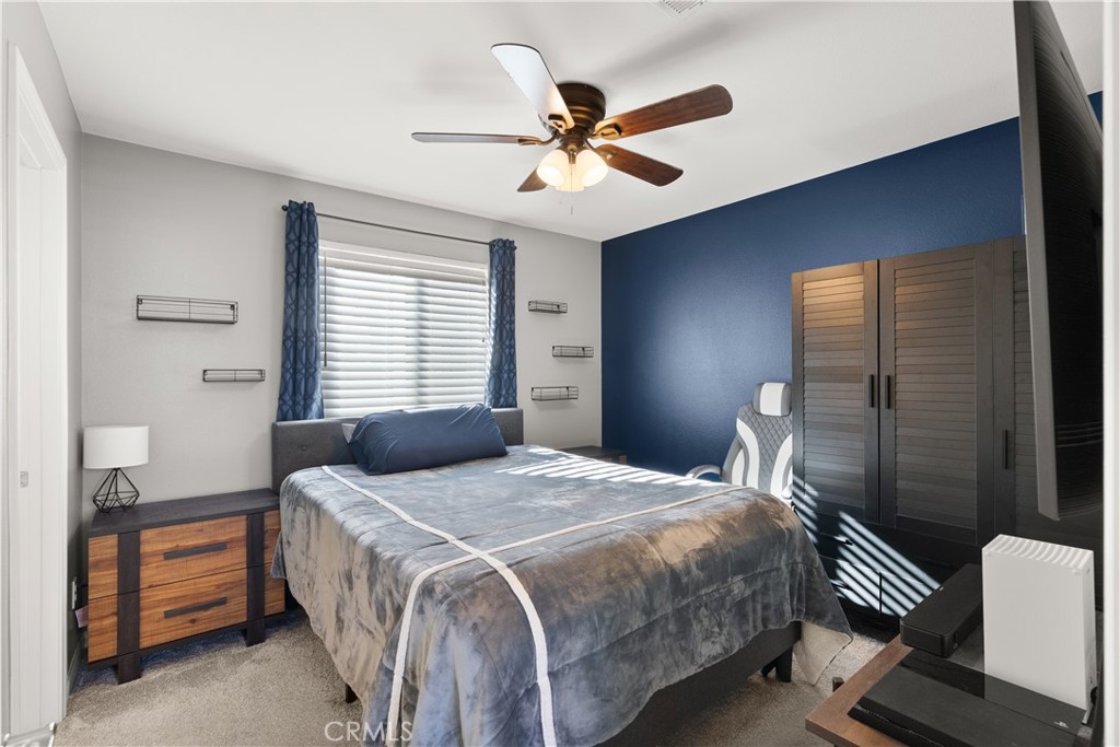 904 Maya Crossing, Unit 19 Lake Elsinore, CA 92530 - Photo 20 of 25 a bedroom with a bed and a chandelier