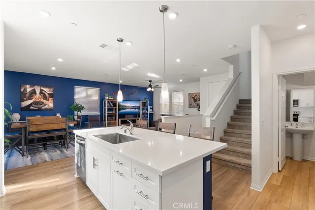 a kitchen with stainless steel appliances kitchen island granite countertop a sink and a refrigerator