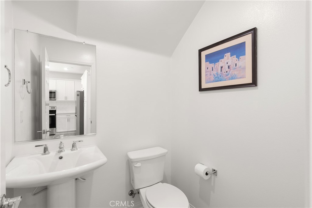 904 Maya Crossing, Unit 19 Lake Elsinore, CA 92530 - Photo 10 of 25 a bathroom with a toilet sink and mirror