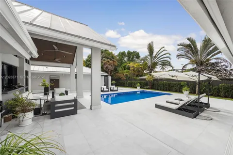 a view of a house with a barbeque and sitting area