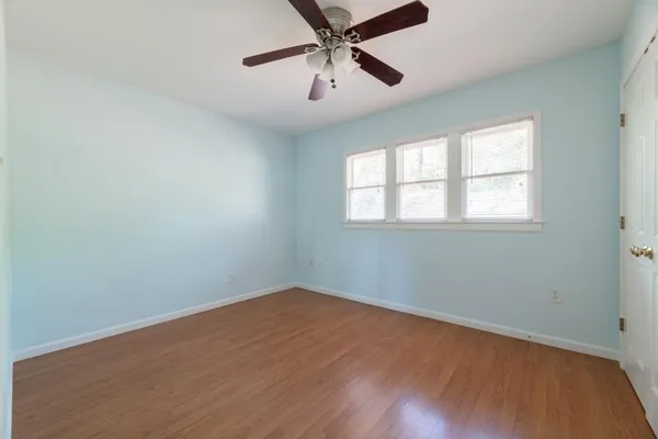 an empty room with a window and a fan