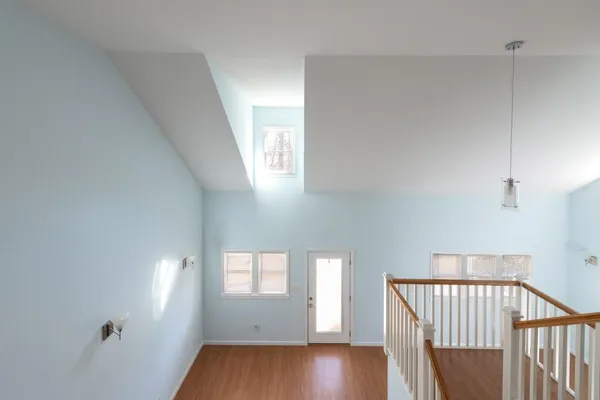 a view of hallway with windows and wooden floor