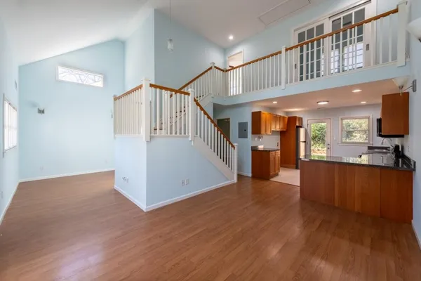 a view of a hallway with wooden floor and staircase