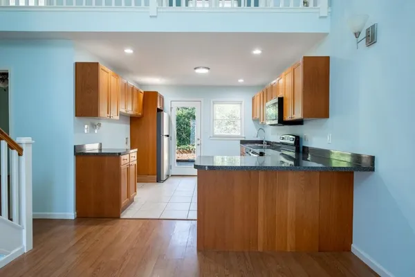 a large kitchen with stainless steel appliances granite countertop a stove a sink and a refrigerator