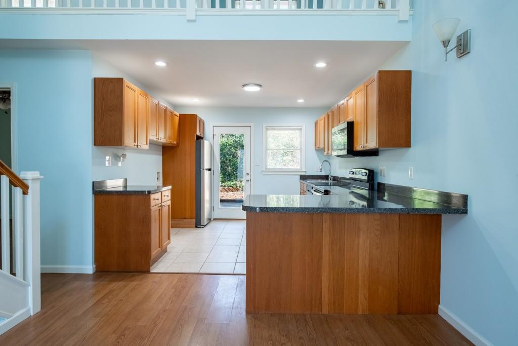 342 Mathews Avenue Northeast, Unit A Atlanta, GA 30307 - Photo 7 of 34 a large kitchen with stainless steel appliances granite countertop a stove a sink and a refrigerator