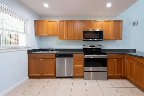 a kitchen with stainless steel appliances granite countertop a stove a sink and a microwave