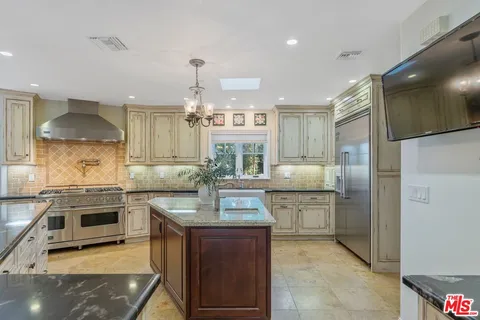 a kitchen with granite countertop stainless steel appliances and wooden cabinets