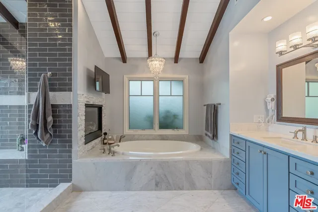 a spacious bathroom with a tub sink and mirror