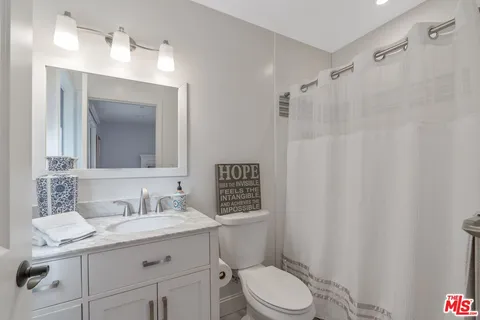 a bathroom with a sink toilet vanity and shower