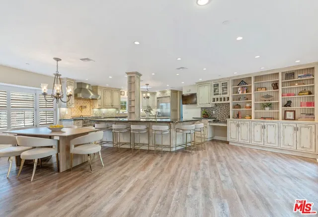 a large white kitchen with a large window and stainless steel appliances
