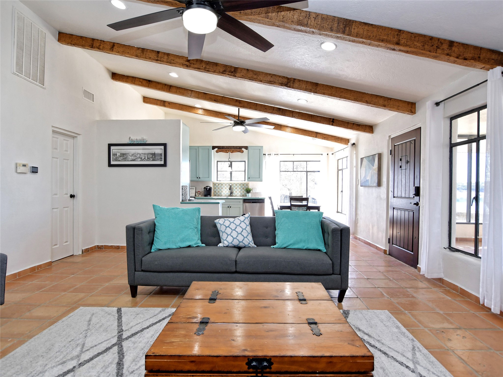 17123 Rocky Ridge Road Austin, TX 78734 - Photo 12 of 26 Vaulted ceilings with exposed wood beams define this living area, featuring terracotta tile flooring and recessed lighting