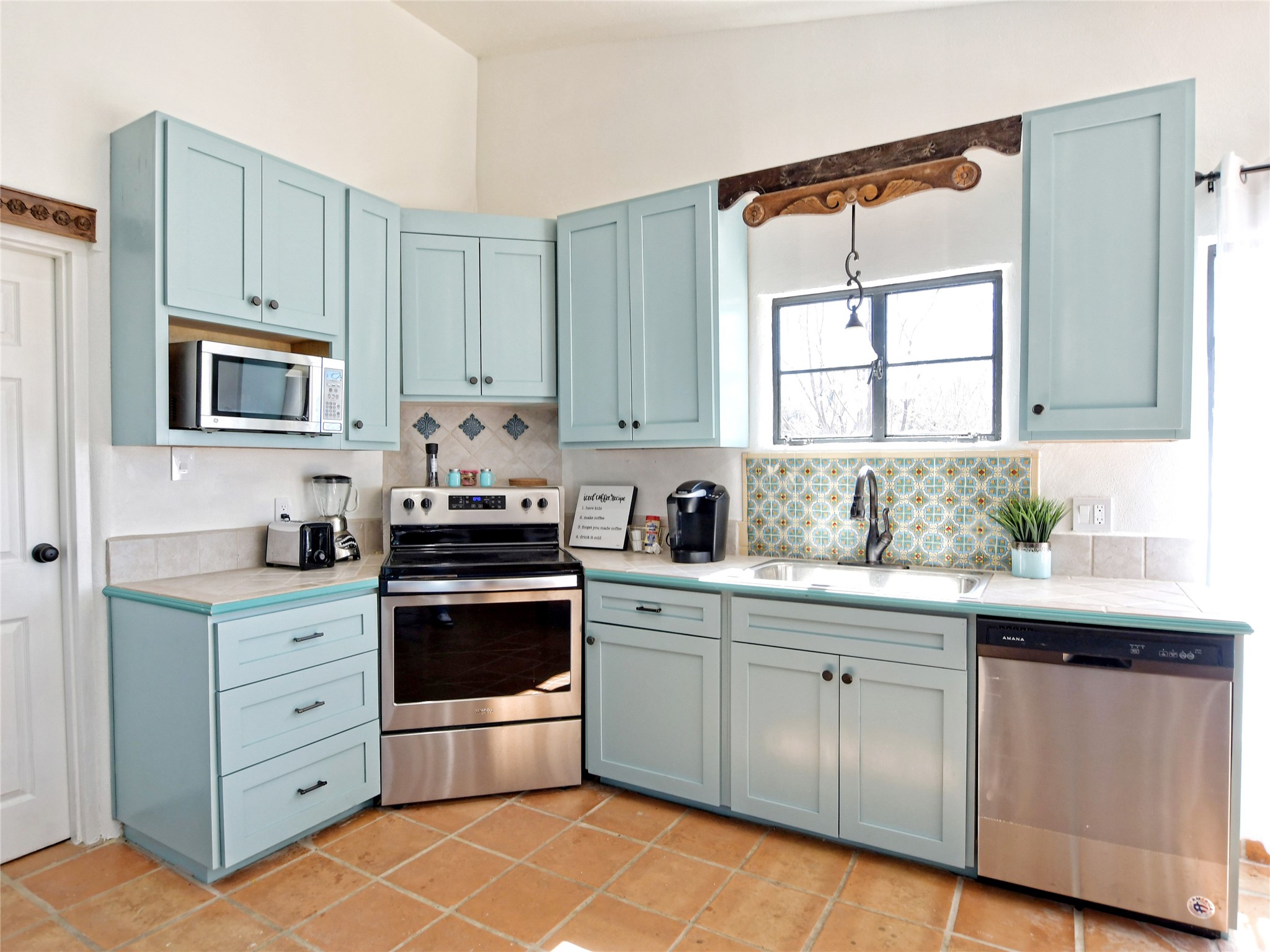 17123 Rocky Ridge Road Austin, TX 78734 - Photo 13 of 26 Kitchen featuring a built-in stainless steel microwave, light blue cabinetry with dark hardware, a stainless steel range, and a stainless steel dishwasher