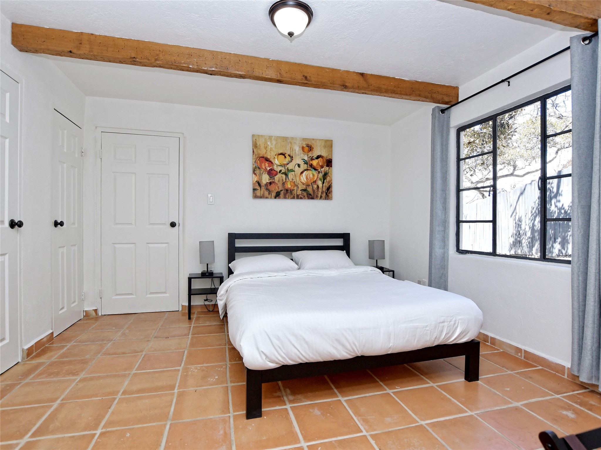 17123 Rocky Ridge Road Austin, TX 78734 - Photo 18 of 26 Room featuring exposed wood beams, terracotta-style floor tiling, and a multi-pane window