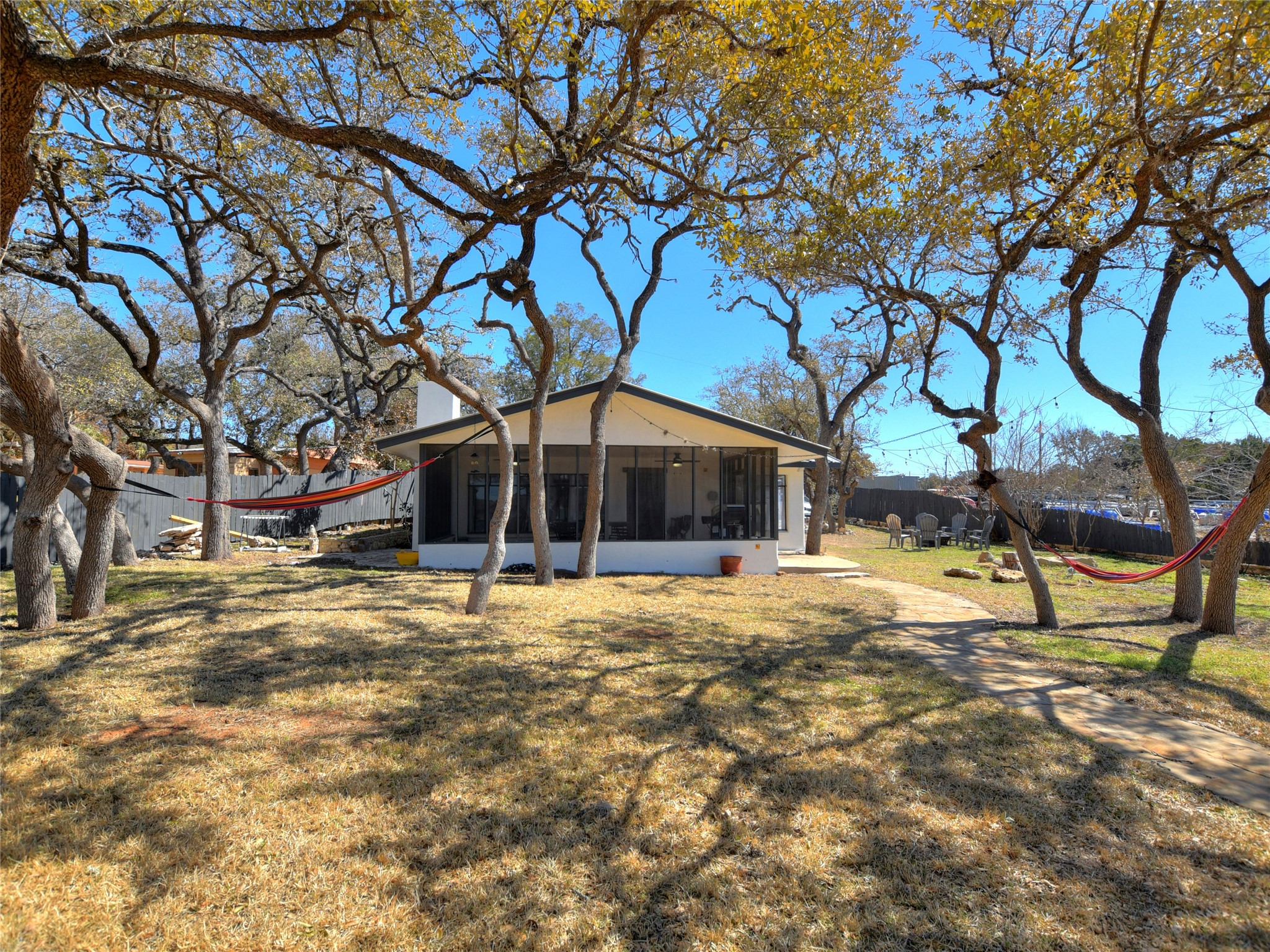 17123 Rocky Ridge Road Austin, TX 78734 - Photo 2 of 26 Expansive backyard featuring mature trees, a screened porch, and a concrete patio