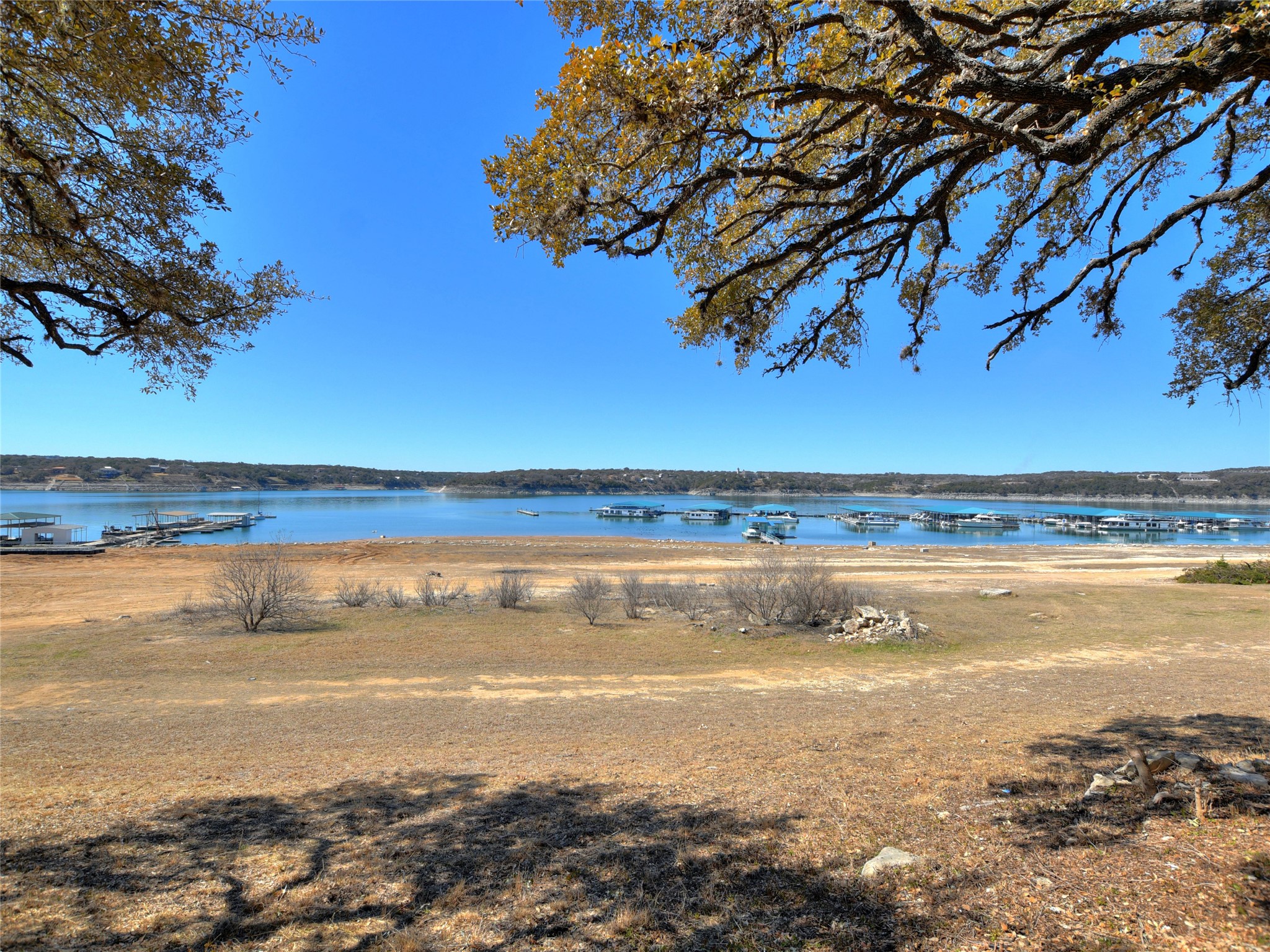 17123 Rocky Ridge Road Austin, TX 78734 - Photo 26 of 26 Expansive waterfront property featuring a wide expanse of water, multiple boat docks, a large land area, and mature trees framing the scenery