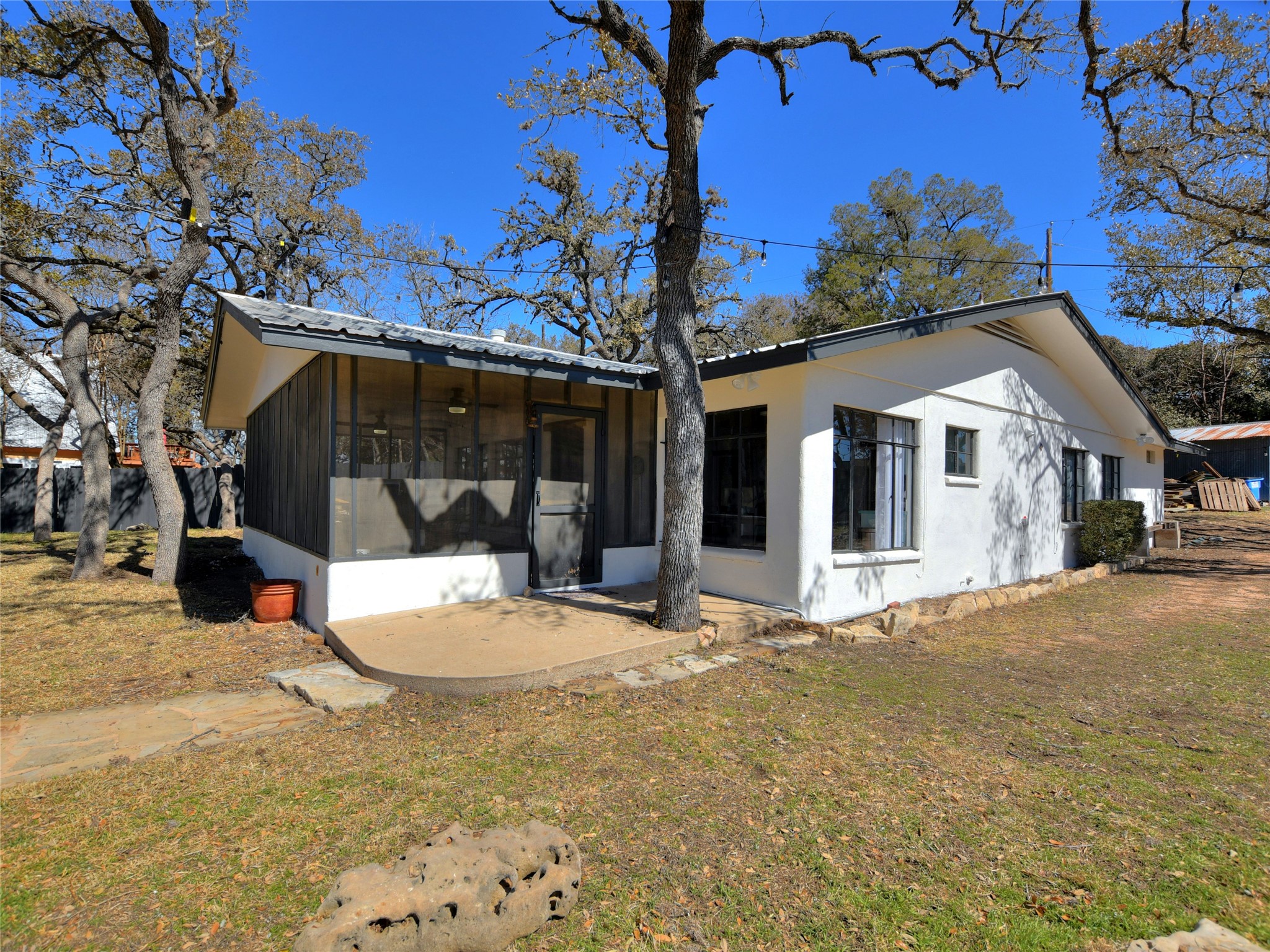 17123 Rocky Ridge Road Austin, TX 78734 - Photo 4 of 26 White stucco exterior with a screened porch and metal roof