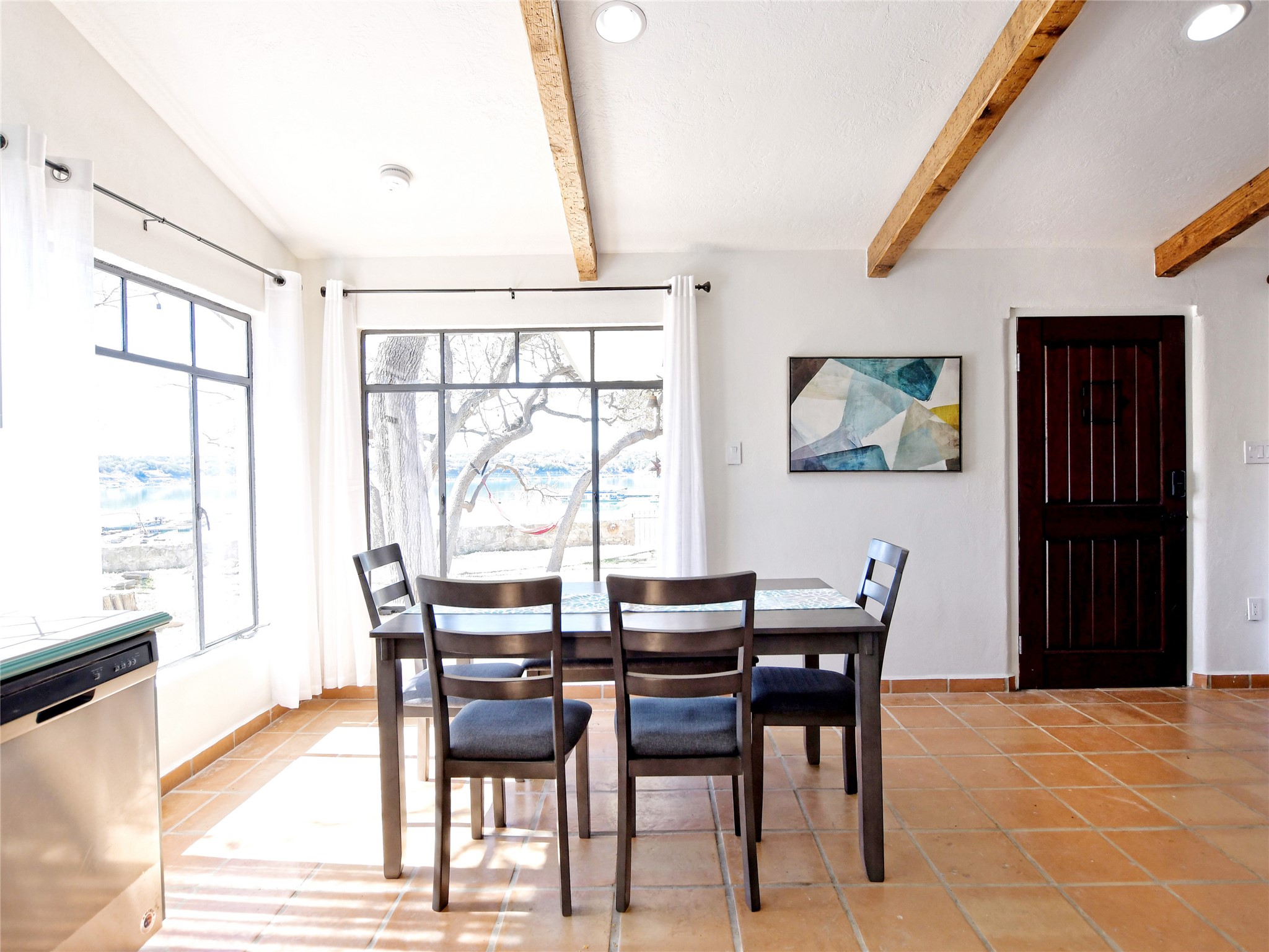 17123 Rocky Ridge Road Austin, TX 78734 - Photo 8 of 26 Dining area featuring prominent exposed wood ceiling beams and terracotta-style floor tiling