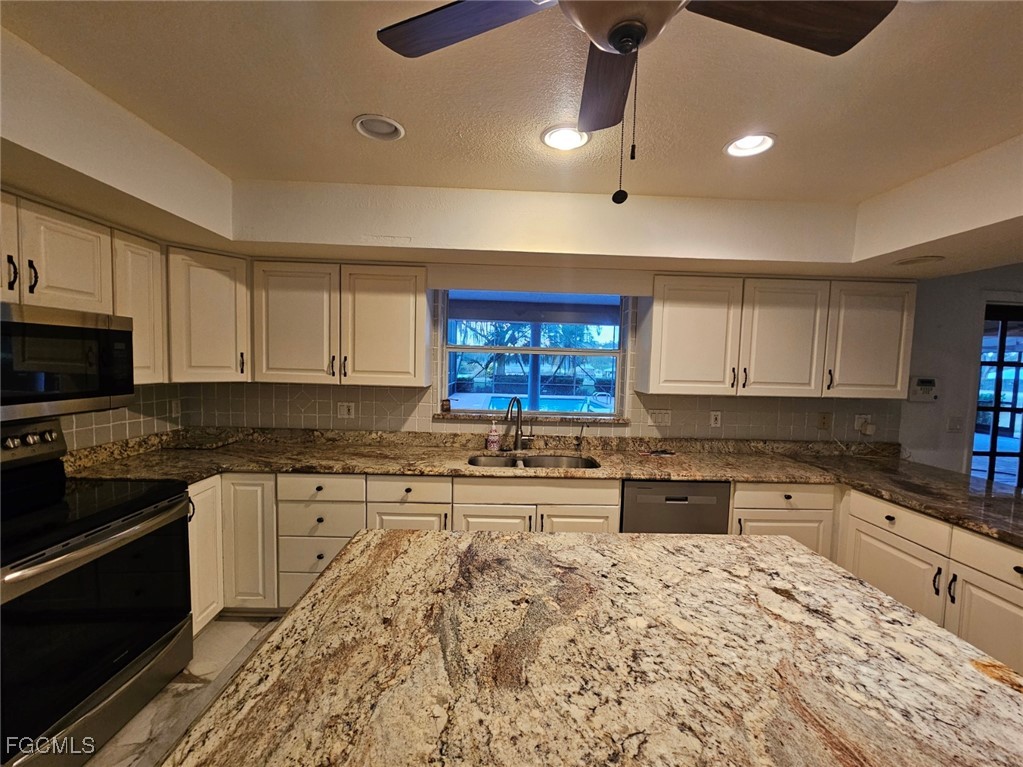 3680 Fort Denaud Road LaBelle, FL 33935 - Photo 21 of 49 a kitchen with stainless steel appliances kitchen island granite countertop a sink and cabinets