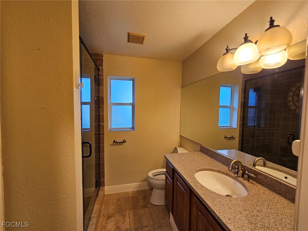 3680 Fort Denaud Road LaBelle, FL 33935 - Photo 29 of 49 a bathroom with a granite countertop sink a toilet and a mirror