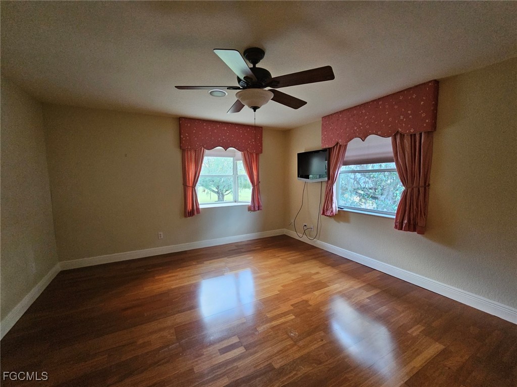 3680 Fort Denaud Road LaBelle, FL 33935 - Photo 39 of 49 an empty room with wooden floor fan and windows