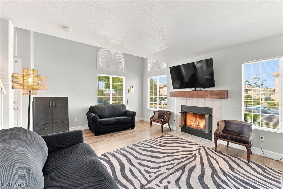 505 Rafkin Place Henderson, NV 89052 - Photo 5 of 35 A welcoming living area boasts light wood flooring and a classic tile fireplace with a robust wood mantle.