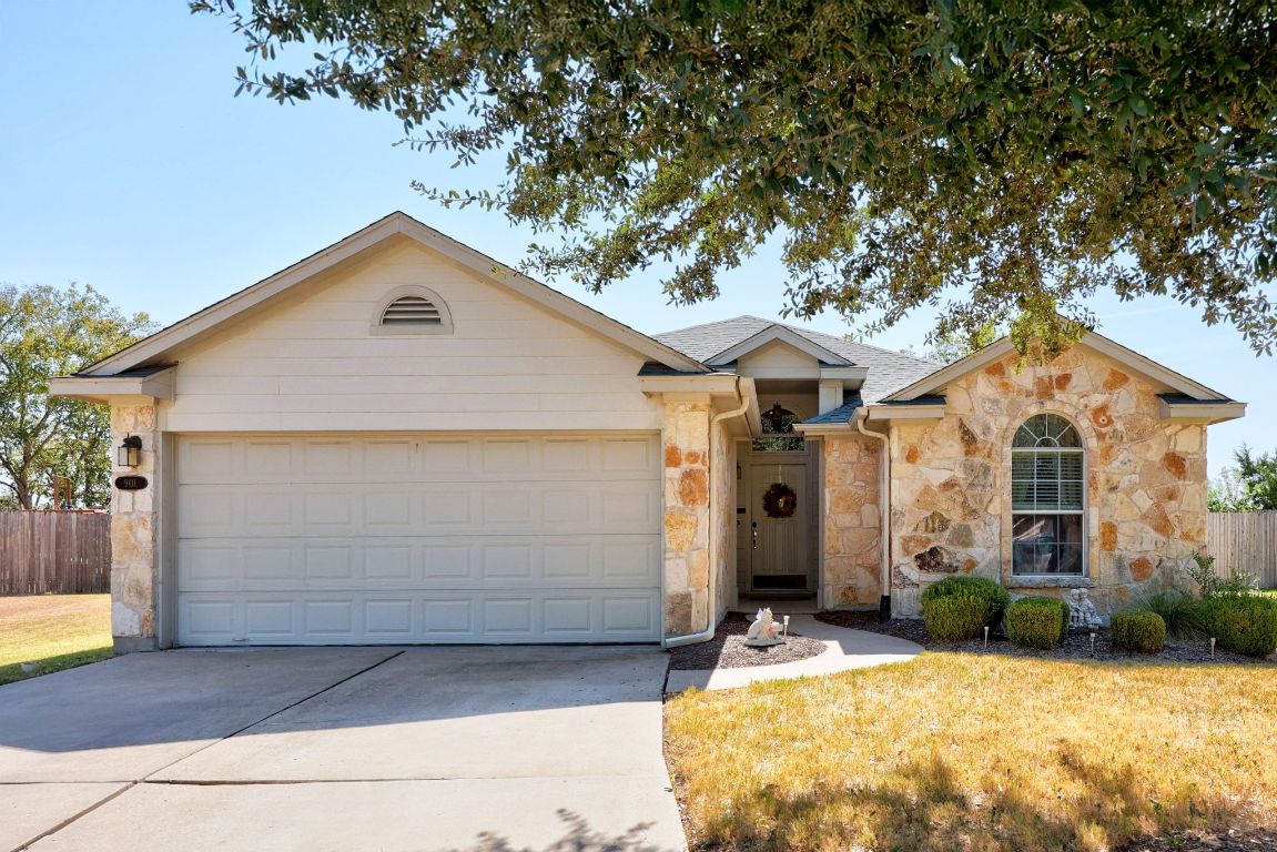 Single story home with stone siding, driveway, an attached garage, and a shingled roof