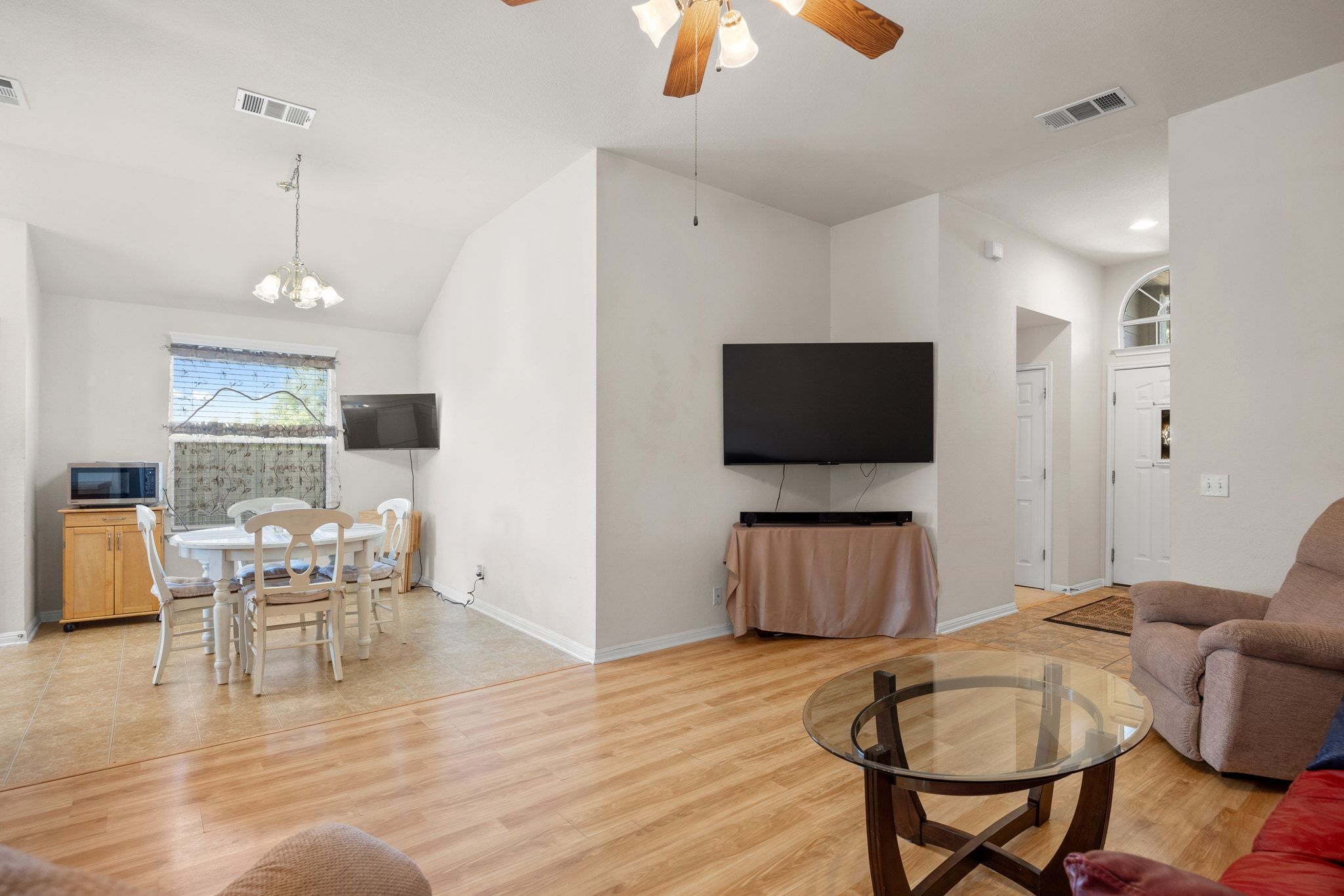 901 Kenneys Way Round Rock, TX 78665 - Photo 11 of 33 Living area featuring light wood-style flooring, lofted ceiling, a ceiling fan, and a chandelier