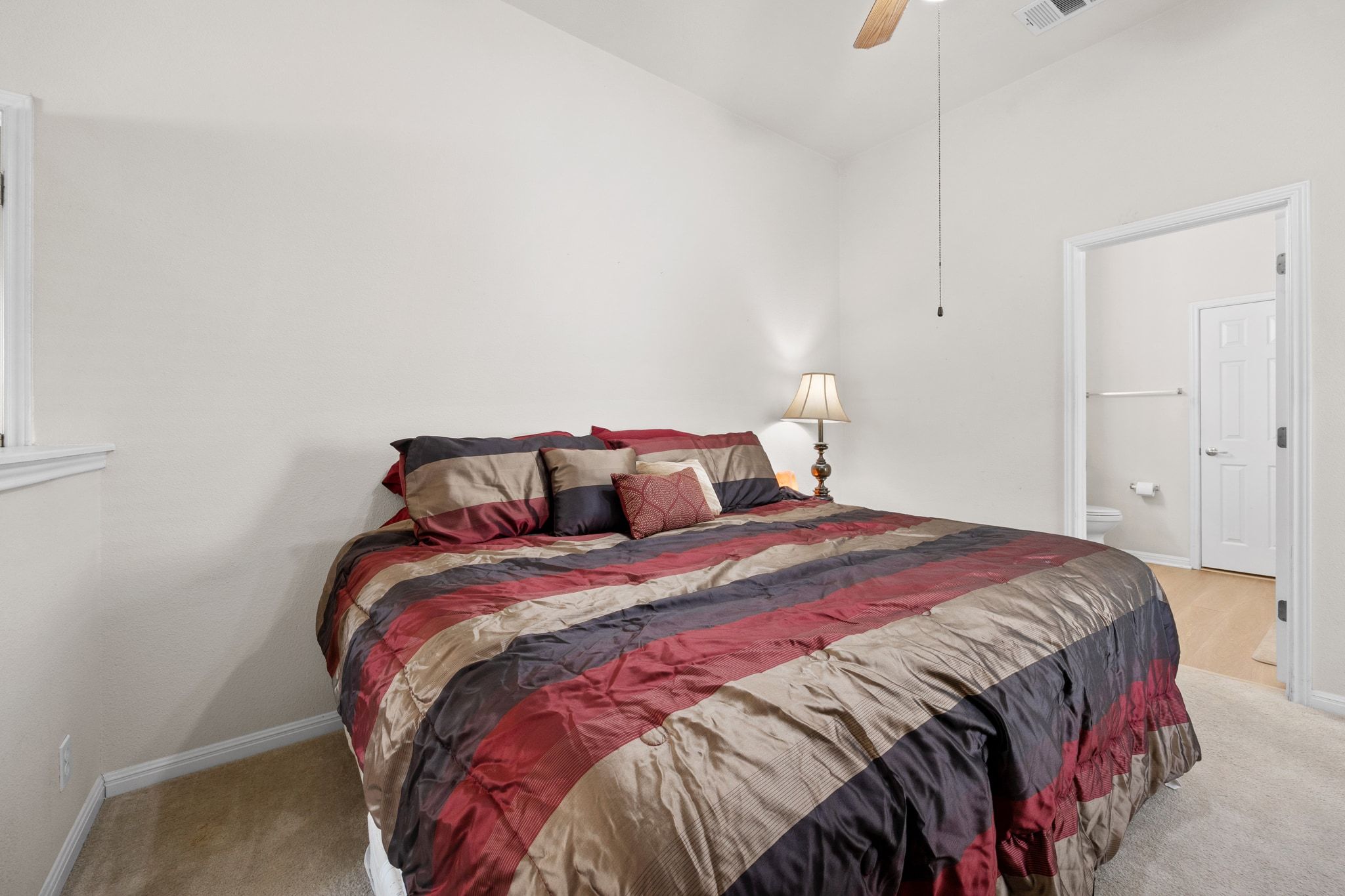 901 Kenneys Way Round Rock, TX 78665 - Photo 19 of 33 Bedroom featuring light colored carpet, ceiling fan, and connected bathroom