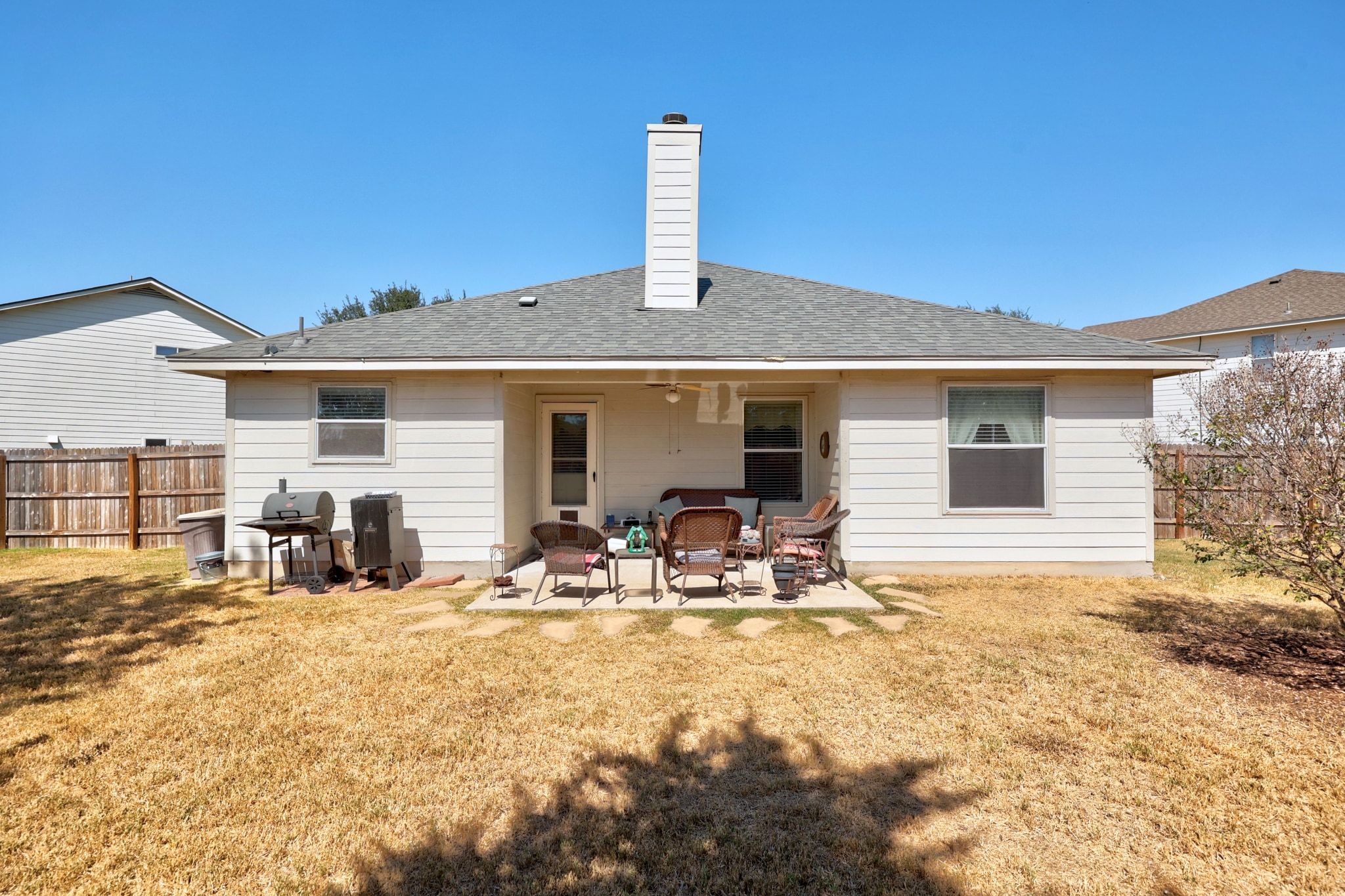 901 Kenneys Way Round Rock, TX 78665 - Photo 29 of 33 Rear view of house with a fenced backyard, a patio area, roof with shingles, and a chimney