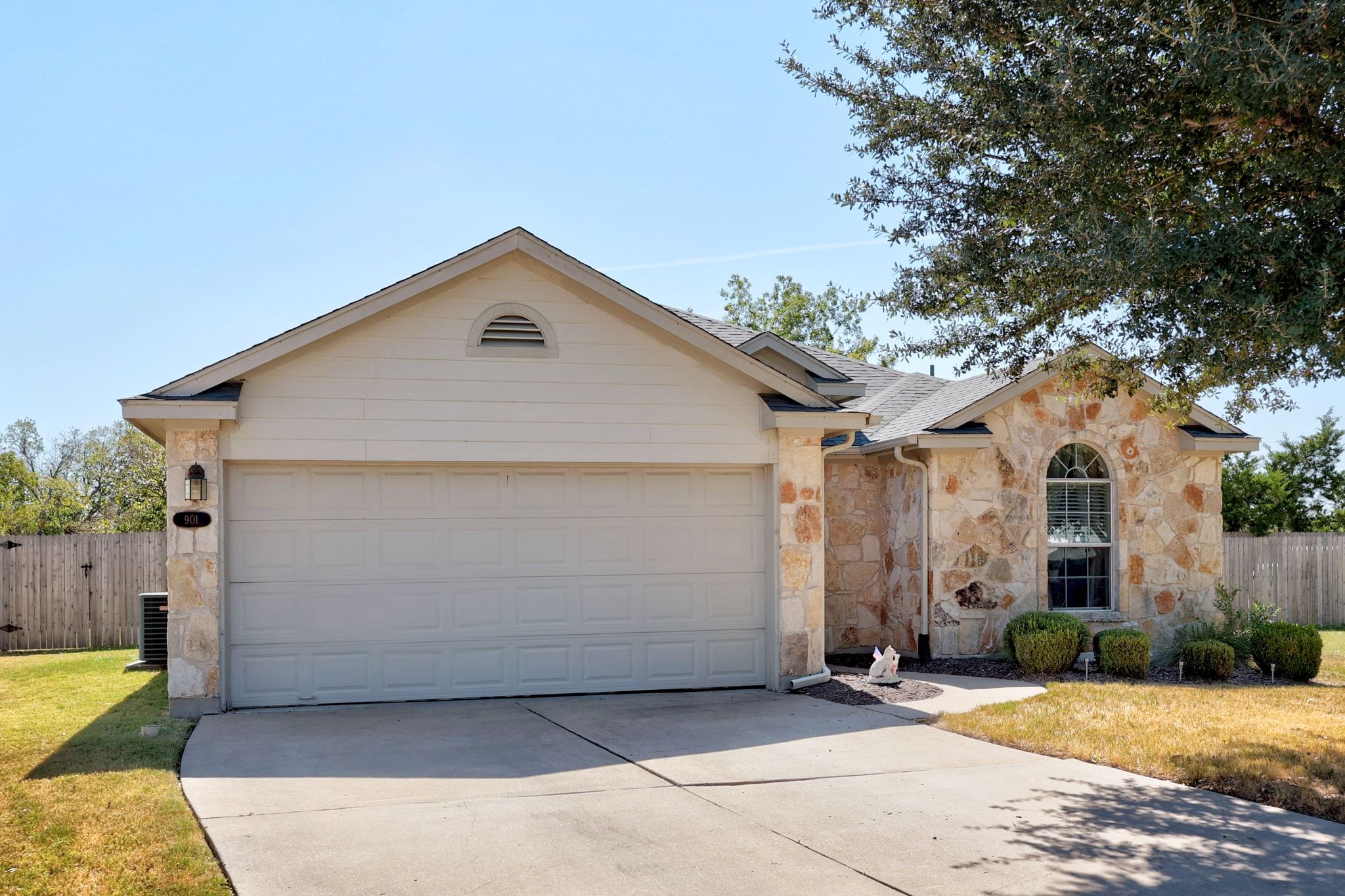 901 Kenneys Way Round Rock, TX 78665 - Photo 3 of 33 Ranch-style home featuring stone siding, roof mounted solar panels, driveway, and roof with shingles