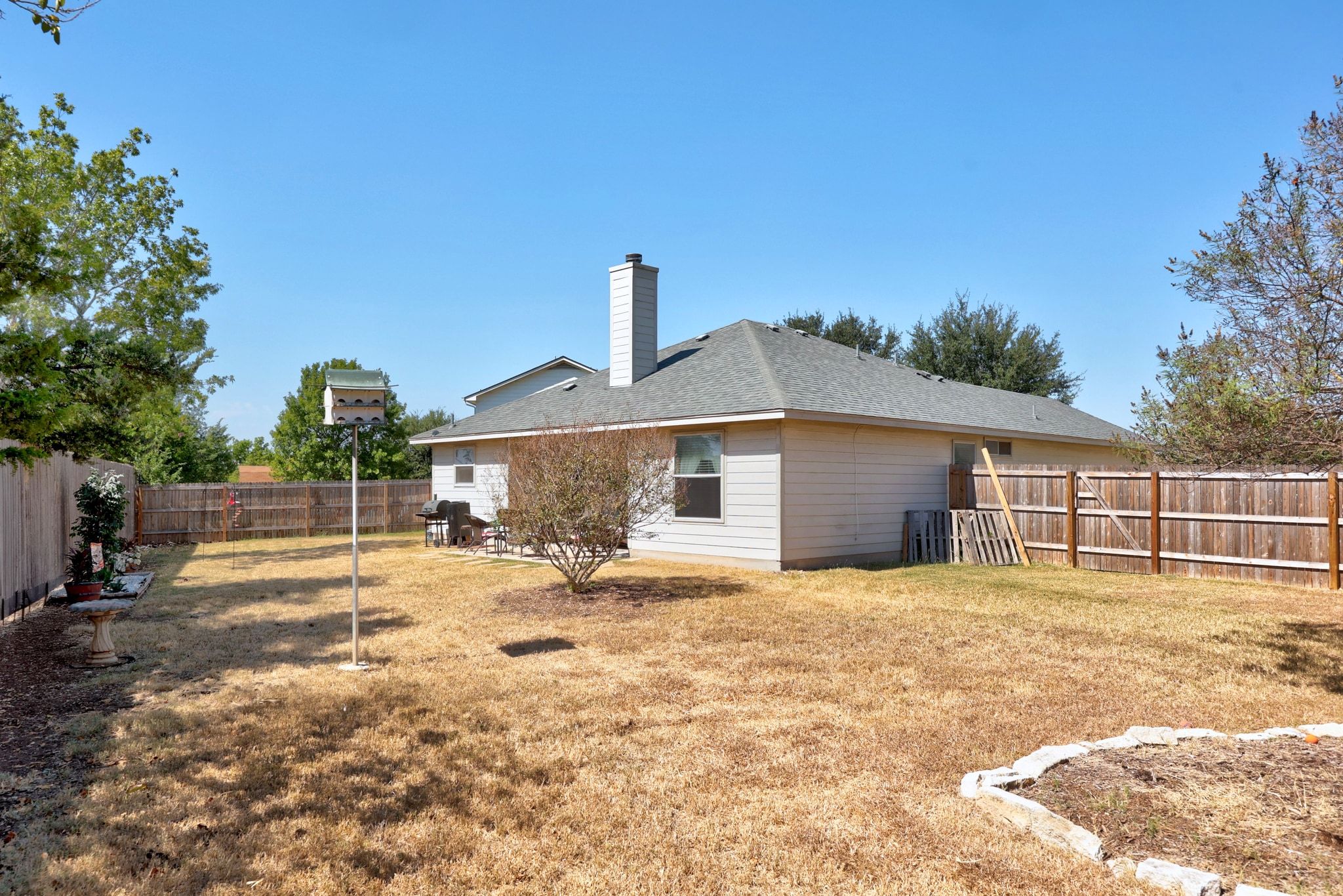 901 Kenneys Way Round Rock, TX 78665 - Photo 32 of 33 Rear view of property featuring a fenced backyard, a chimney, and roof with shingles
