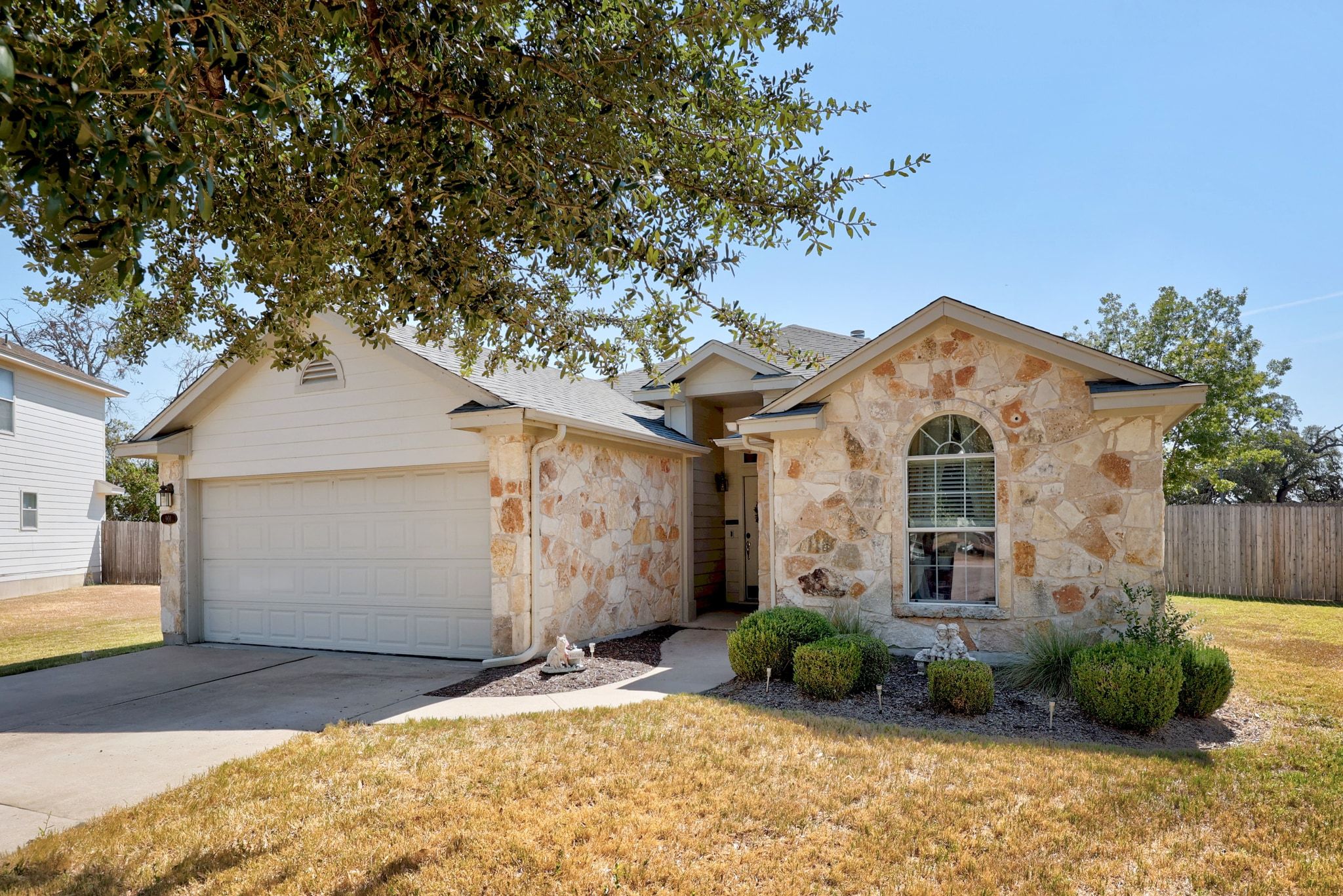 901 Kenneys Way Round Rock, TX 78665 - Photo 4 of 33 View of front facade with stone siding, driveway, an attached garage, and roof with shingles