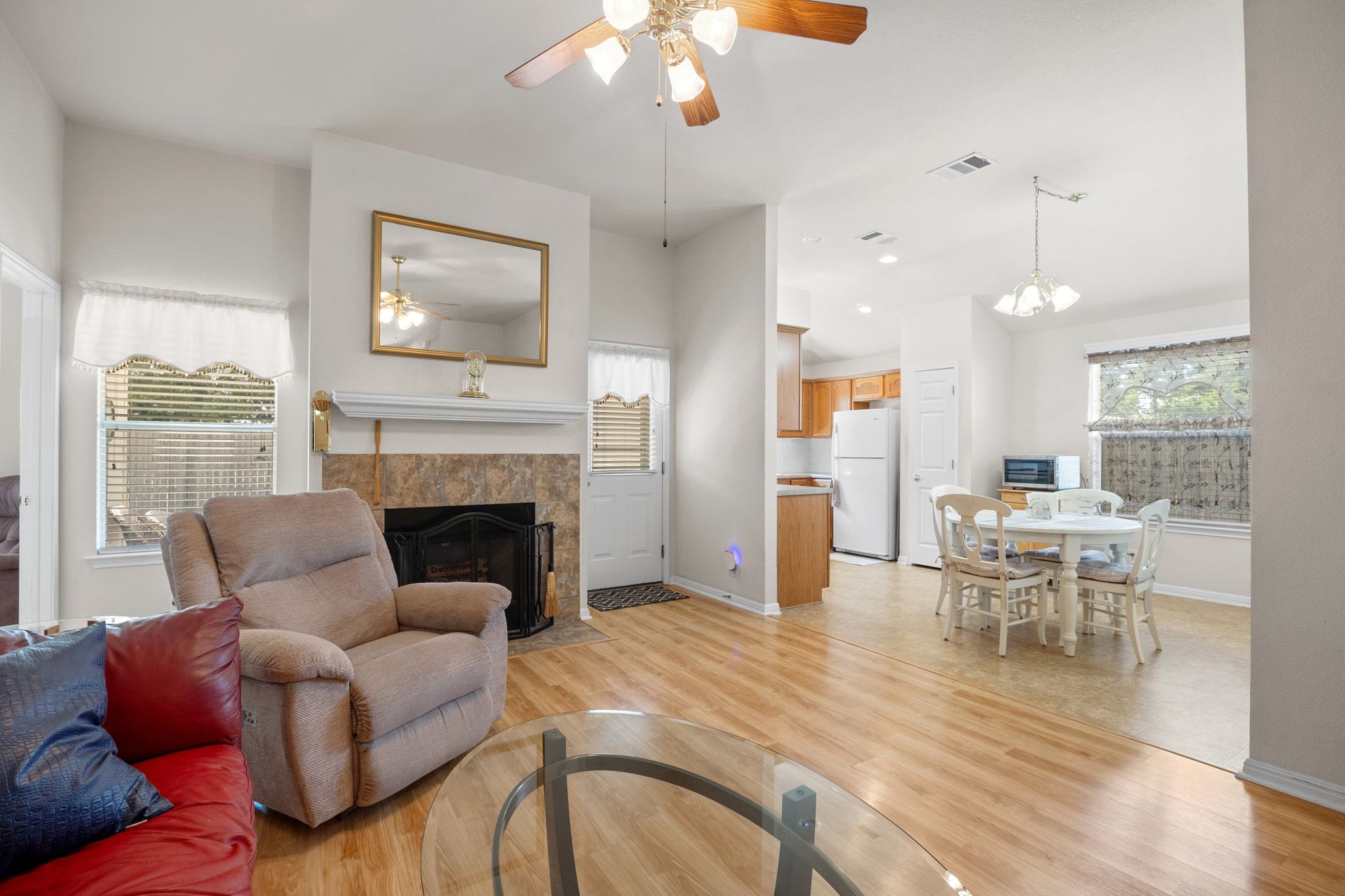 901 Kenneys Way Round Rock, TX 78665 - Photo 10 of 33 Living area with a ceiling fan, light wood finished floors, a tiled fireplace, and a chandelier