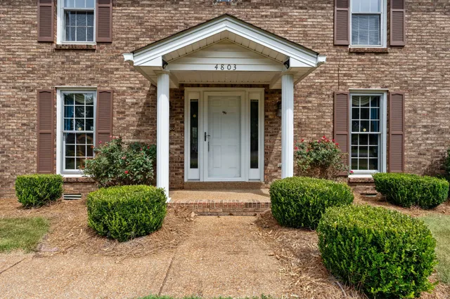 front view of a brick house with a large window