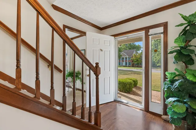 a view of an entryway door and wooden floor