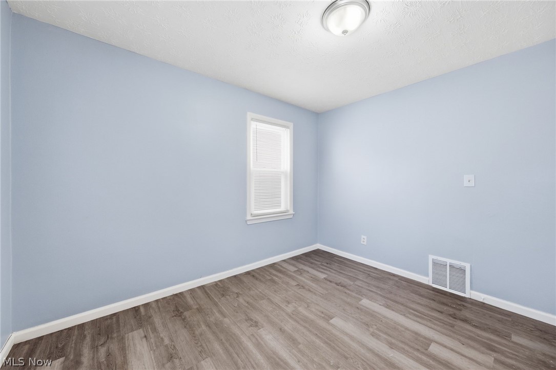 20705 Hansen Road Maple Heights, OH 44137 - Photo 9 of 24 Empty room featuring wood finished floors and a textured ceiling