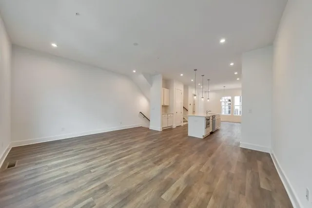 a view of a big room with wooden floor and windows