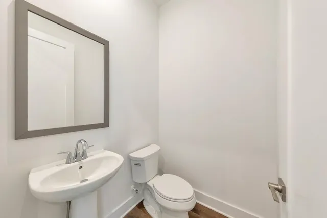 a bathroom with a sink a toilet and a mirror